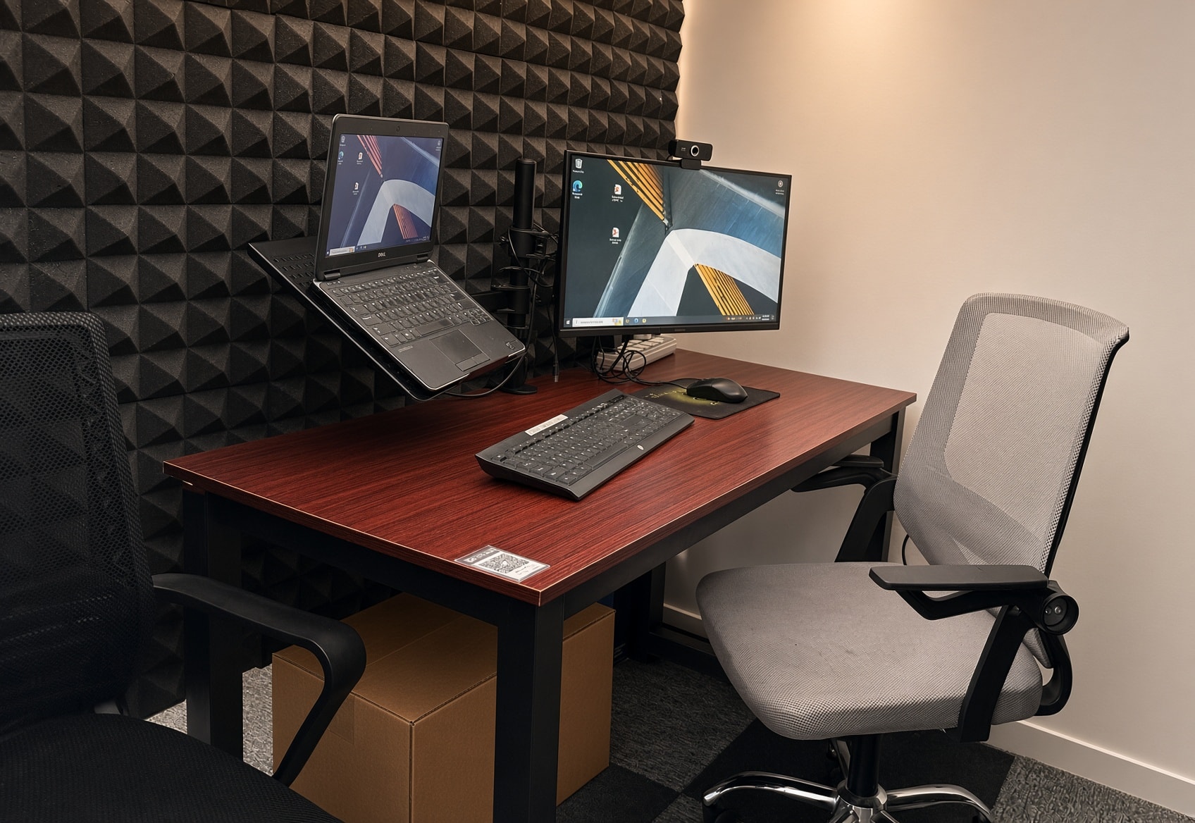 Private desk pod with monitor and ergonomic chair