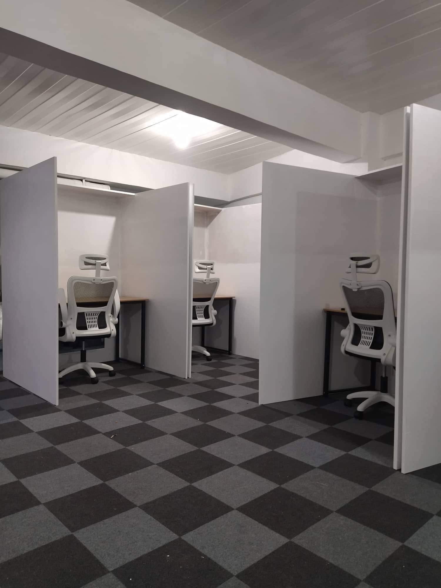 Row of private work pods with checkered flooring